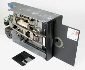8 Inch floppy disk drive and disk next to a 3.5" floppy disk to show side comparison