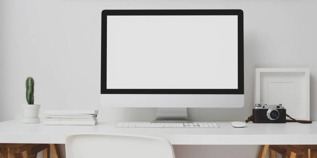 desktop computer beside analog camera