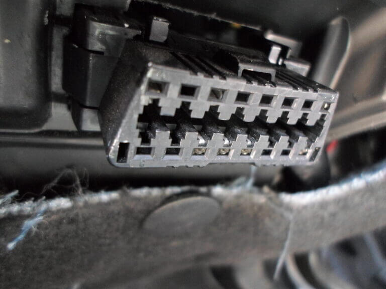 Onboard Diagnostics (ODB-II) port on a vehicle used to connect a cable to a reader to read the car's diagnostic information