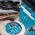 Laptop fan and heatsink partially choked with fluff and debris