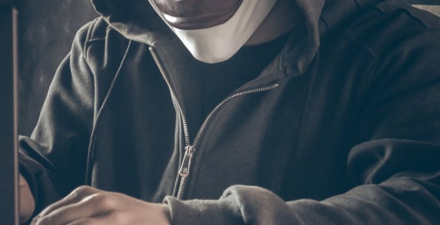 Anonymous computer hacker in white mask and hoodie.