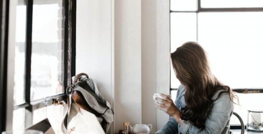 woman in gray jacket sitting beside desk