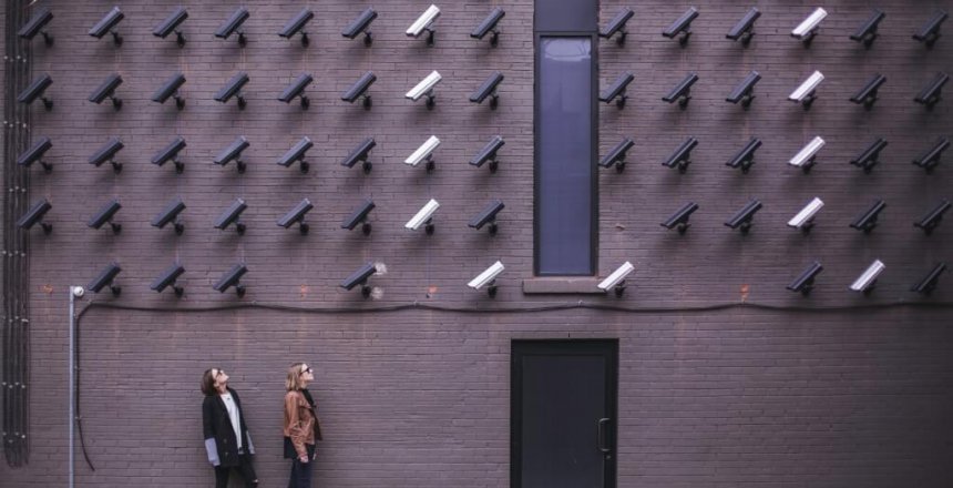 two person standing under lot of bullet cctv camera